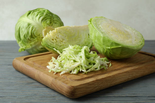 istock Board with fresh green cabbage on wooden background 1310043324
