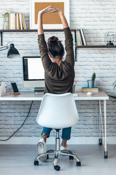 istock Beautiful businesswoman stretching body for relaxing while working with computer in the office at home. 1310044176
