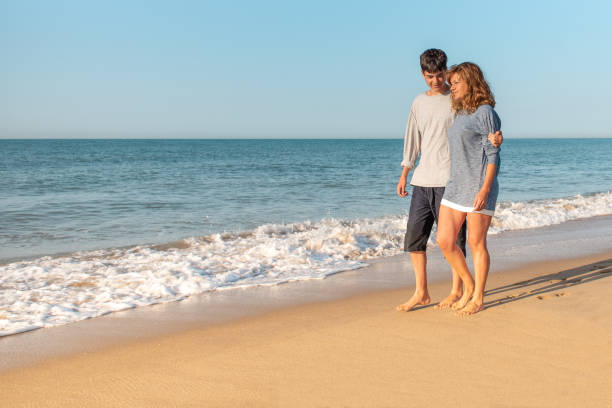 istock Mother and son talking and strolling on the beach 1310044339