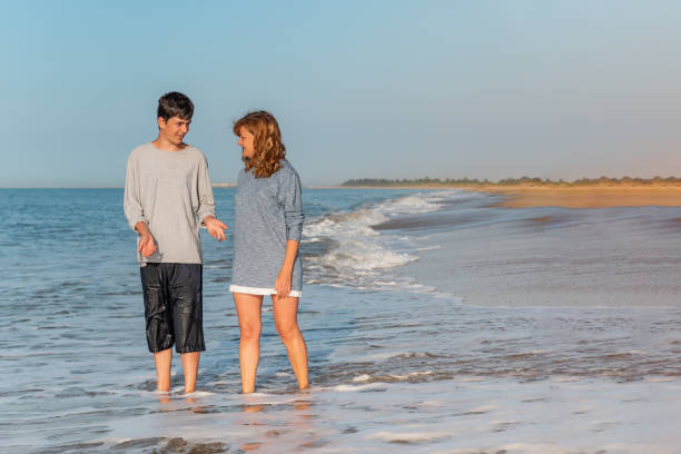istock Mother and son talking and strolling on the beach 1310044409