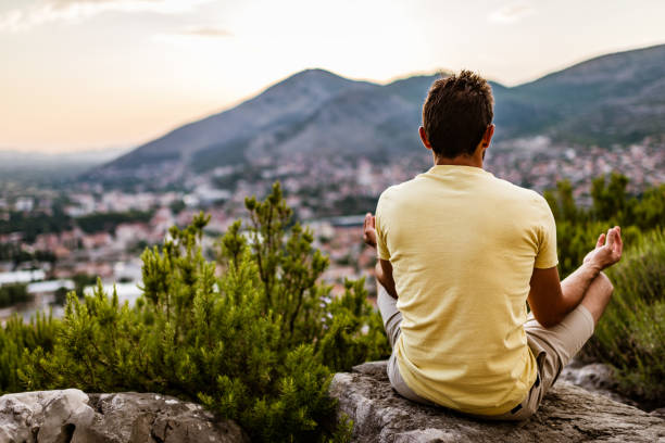istock Young man preforms yoga in mountains at sunset 1310045192