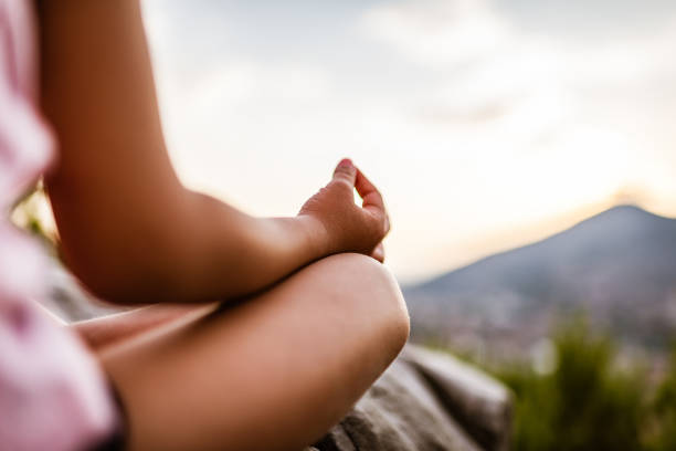 young girl preforms yoga in mountains at sunset - zen like nature breathing exercise sitting imagens e fotografias de stock