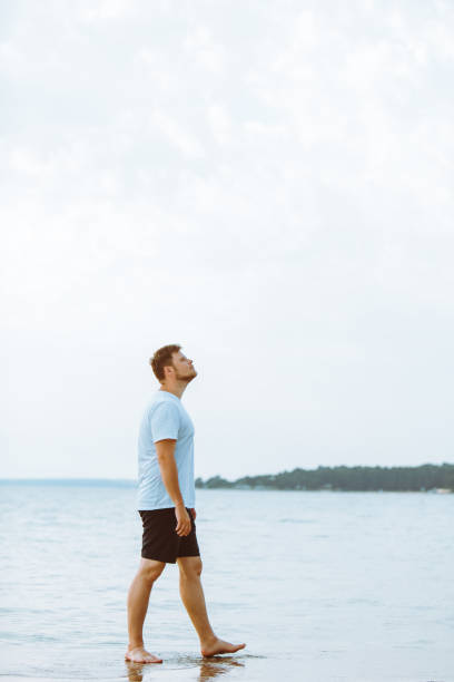 istock man walking barefoot by sea beach summer time 1310046842