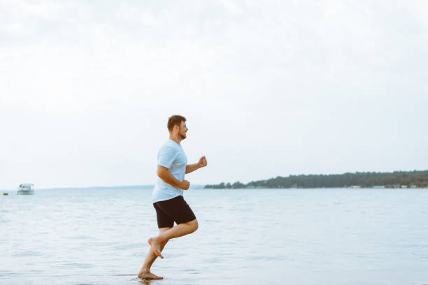 istock man running by sea beach barefoot 1310046843