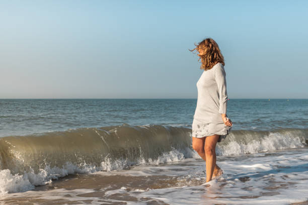 istock Woman on the beach playing in the waves 1310047891