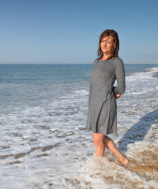 istock Woman walking on the beach looking backwards 1310047962