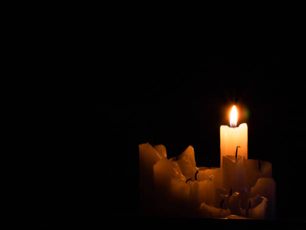 istock a group of burned out candles, one still burning in the dark 1310048737