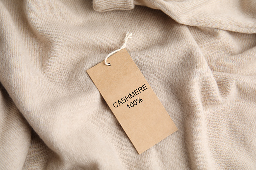 Warm beige cashmere sweater with label, closeup