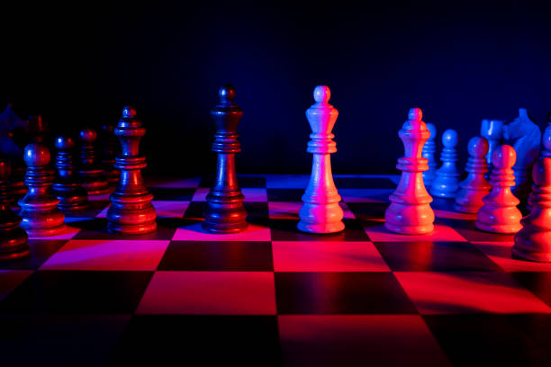 istock Chess figures on a chessboard. Studio neon lights, blue, red, pink and purple. Focus on king 1310051319