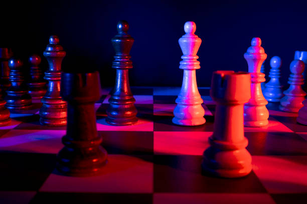 istock Chess figures on a chessboard. Studio neon lights, blue, red, pink and purple. Focus on king 1310051332