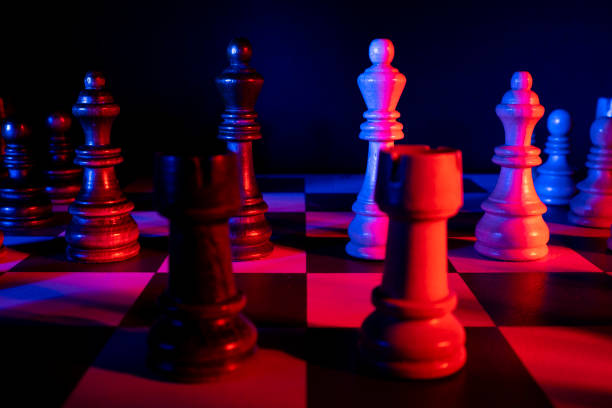 istock Chess figures on a chessboard. Studio neon lights, blue, red, pink and purple. Focus on king 1310051338