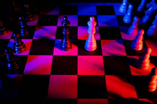 istock Chess figures on a chessboard. Studio neon lights, blue, red, pink and purple. Focus on king 1310051357