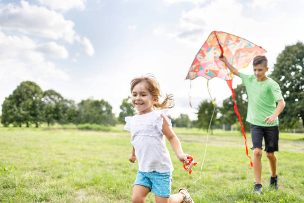 istock Brother and sister playing with kite 1310052585