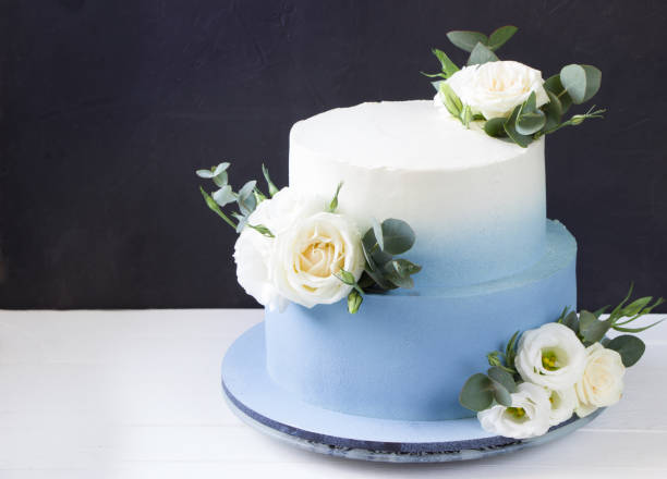 istock Two tiered modern  blue wedding cake with white roses and eucalyptus 1310054516