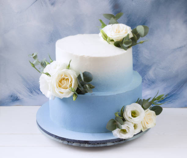 istock Two tiered modern  blue wedding cake with white roses and eucalyptus 1310054522