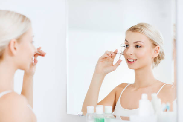 istock woman with curler curling eyelashes at bathroom 1310055710