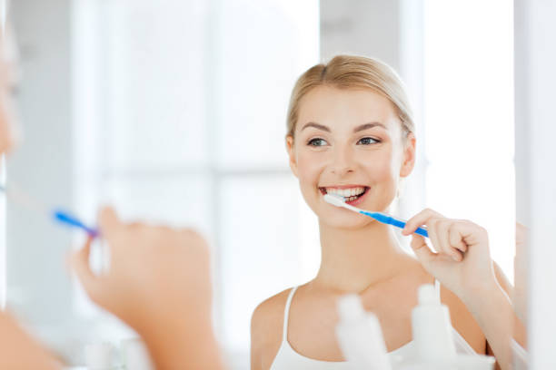istock woman with toothbrush cleaning teeth at bathroom 1310055944