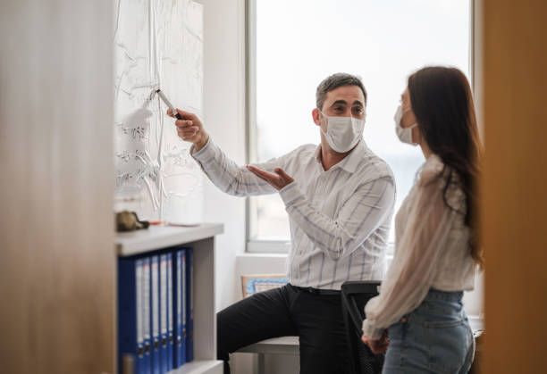 istock Business People With Protective Face Mask Discussing 1310055958
