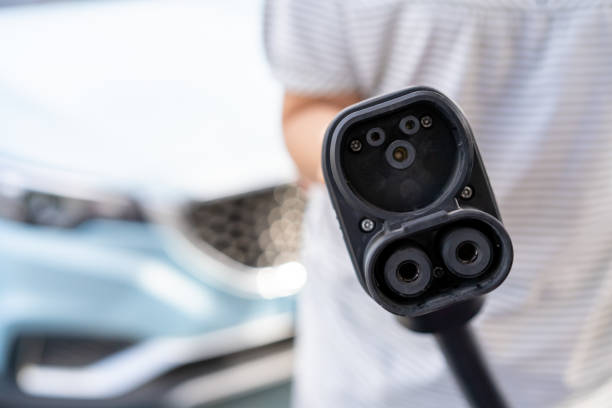 istock Woman picking up a EV Charher cable. 1310056276