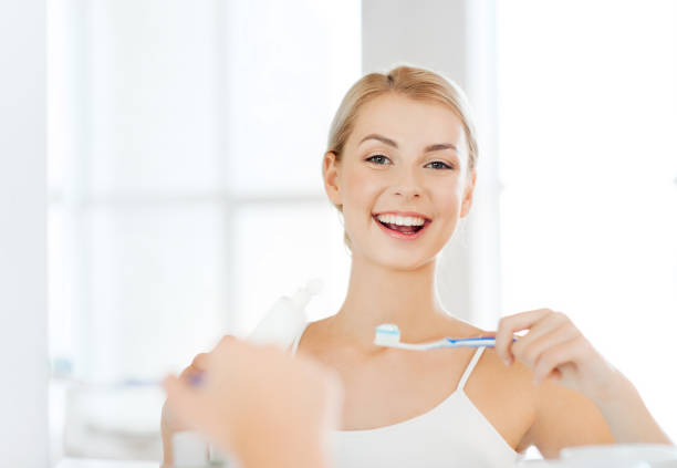 istock woman with toothbrush cleaning teeth at bathroom 1310057533