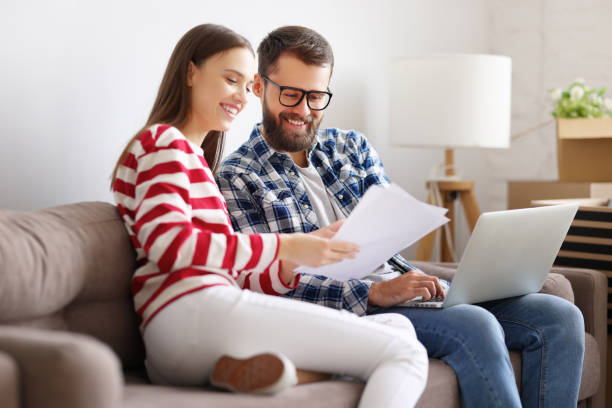 coppia allegra con laptop che discute l'assicurazione della nuova casa - 16607 foto e immagini stock