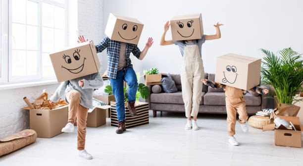 istock Cheerful family in carton boxes having fun during relocation 1310058363