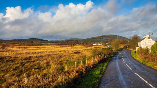 The A762 at Mossdale in Dumfries and Galloway on a sunny winter day, with Bennan Hill and the Galloway Forest Park in the background, Scotland stock photo