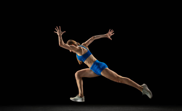 istock Active woman, track athlete training isolated over black studio background. 1310060759