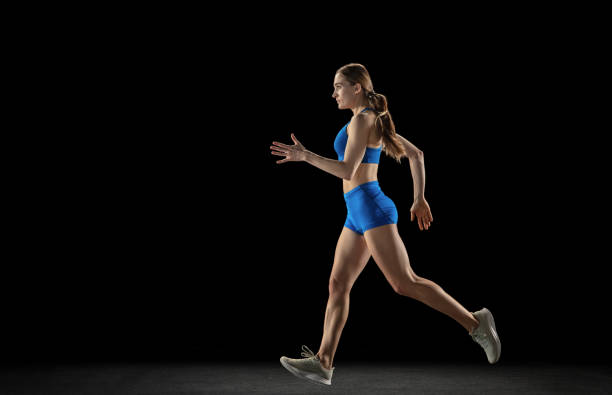 istock Sportive woman, track athlete training isolated over black studio background. 1310060779