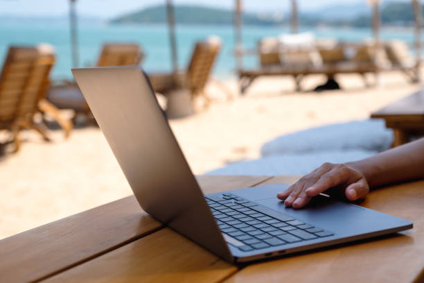 istock a woman working and touching on laptop touchpad on the beach 1310063509