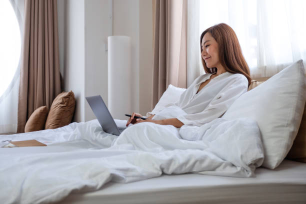 istock A beautiful young asian woman using and working on laptop computer while lying on bed at home 1310063673