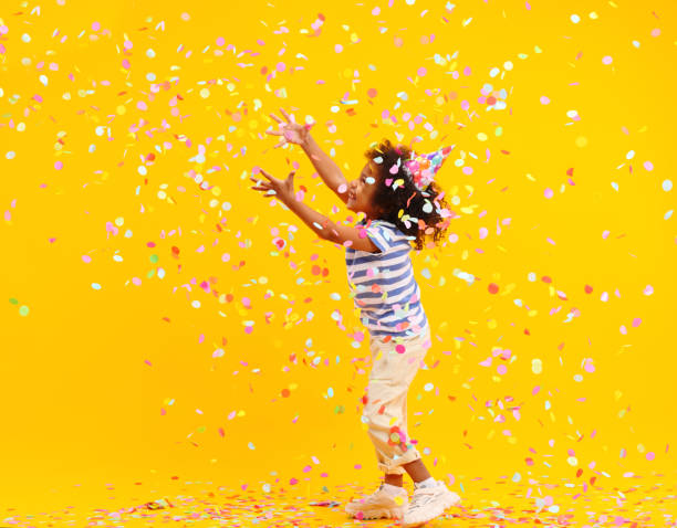 istock Excited African American kid jumping and catching confetti in studio 1310063818