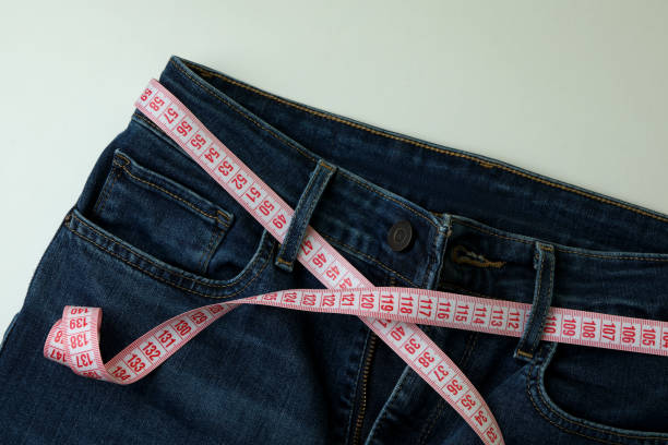 istock Jeans with measuring tape on white background 1310063898