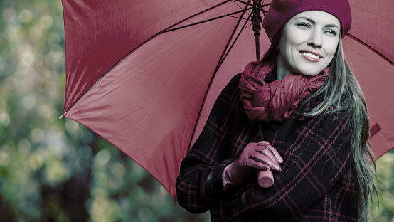 Portrait of a beautiful woman with an umbrella, toned image in dramatic colors