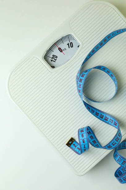 istock Scales with measuring tape on white background 1310064915