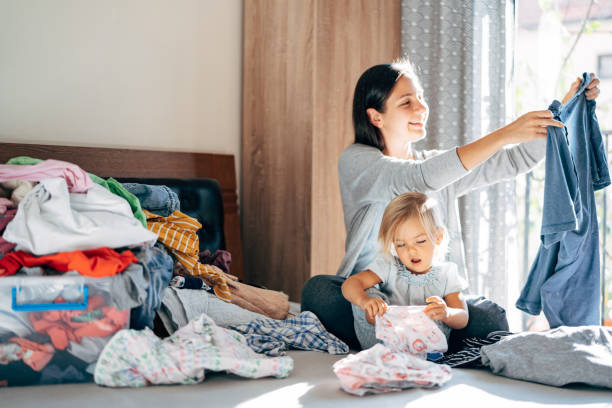 istock Smiling Mother And Daughter Folding Clothes At Home 1310067837