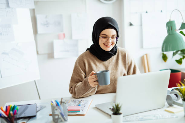 istock Middle Eastern woman working on laptop in office and having video call with partners 1310070609