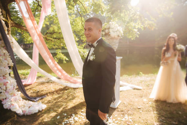 istock Groom standing by the decorated tree and waiting for bride 1310075420