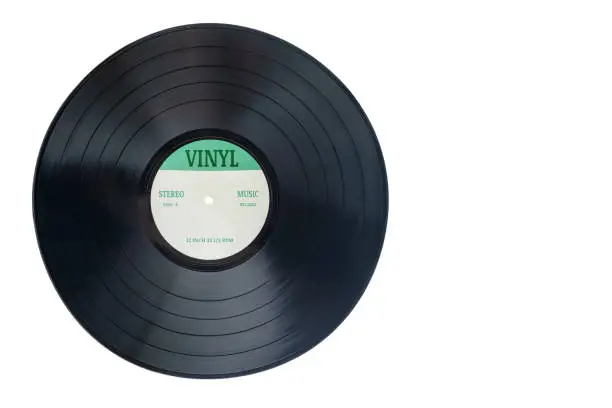 Photo of Closeup view of gramophone vinyl LP record or phonograph record with green label. Black musical long play album disc 12 inch 33 rpm spiral groove. Stereo sound record. Isolated on white background.