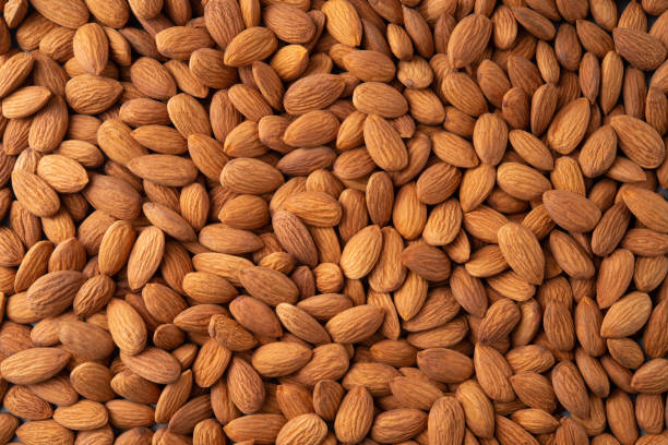 istock Almonds. Almond background. Almonds top view background. Whole nuts flat lay. Full depth of field. 1310078262