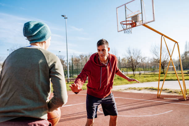 istock Millennials playing basketball outdoors in winter or autumn 1310079559