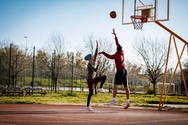 istock Millennials playing basketball outdoors in winter or autumn 1310079600