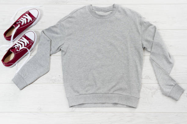 Close up gray blank template sweatshirt hoodie with copy space. Top view mockup pullover on white wooden background. Casual outfit. Flat lay template clothes.