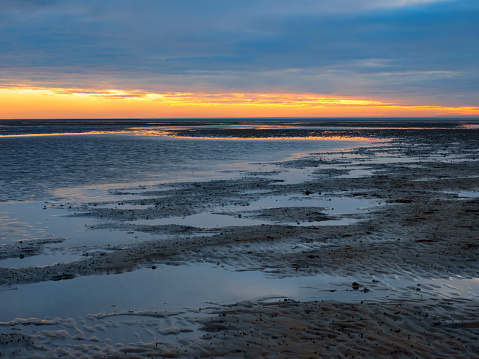 Sunset in the Lower Saxony Wadden Sea off Cuxhaven Sahlenburg at low tide, Germany