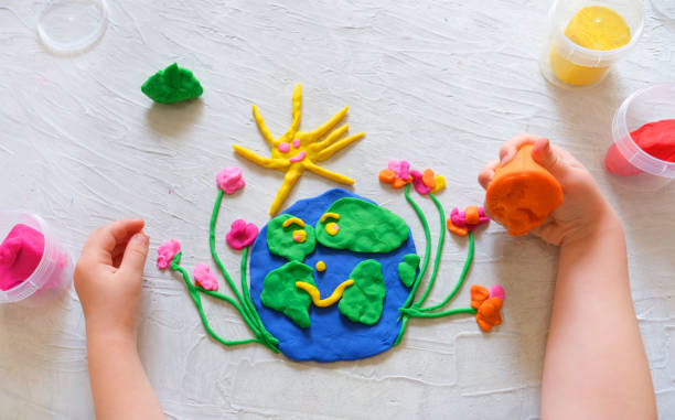 Child sculpturing plasticine planet for earth day.