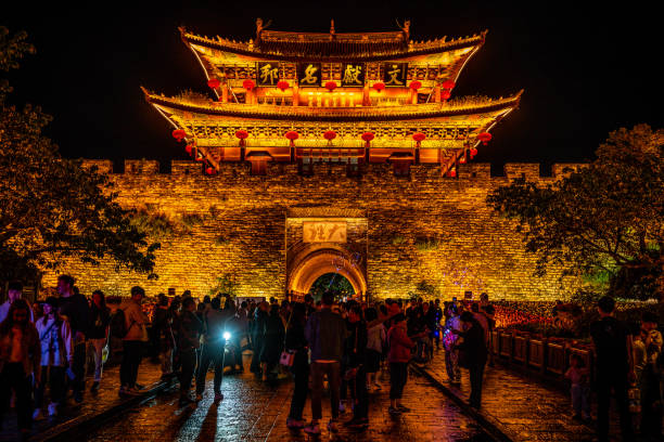 Dali old town south gate illuminated at night and crowd of people in Dali Yunnan China Dali China , 5 October 2020 : Dali old town south gate illuminated at night and crowd of people in Dali Yunnan China yunnan province stock pictures, royalty-free photos & images