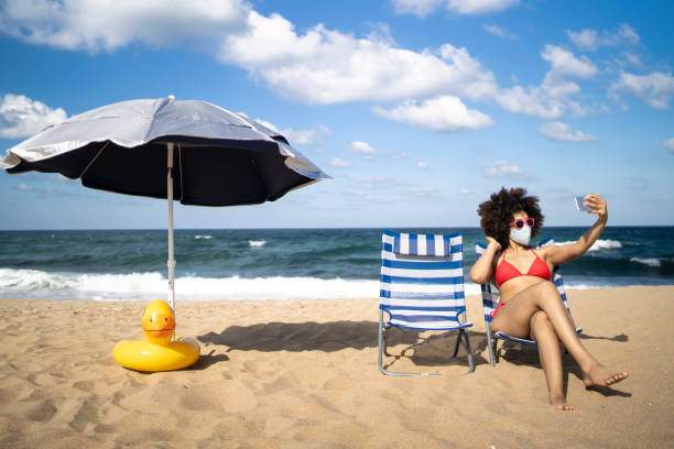 istock Sun bathing in new coronavirus conditions, taking a selfie 1310088165