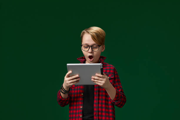 istock child boy in red checkered shirt using digital tablet 1310089324