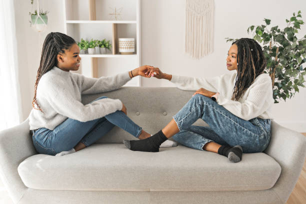 istock Mother and daughter sitting on sofa at home 1310089472