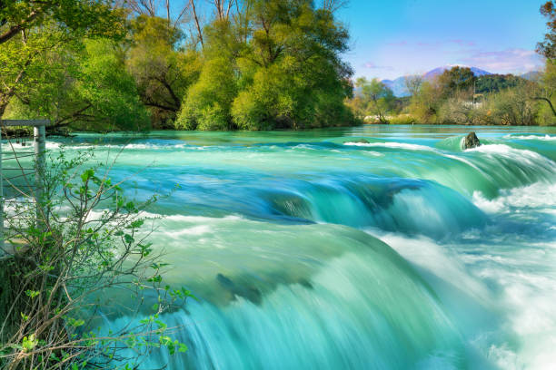 hermoso paisaje natural de la cascada de manavgat en el parque nacional en el soleado día de primavera. color azul único del agua con salpicaduras, side, antalya, turquía - water waterfall sky seascape fotografías e imágenes de stock